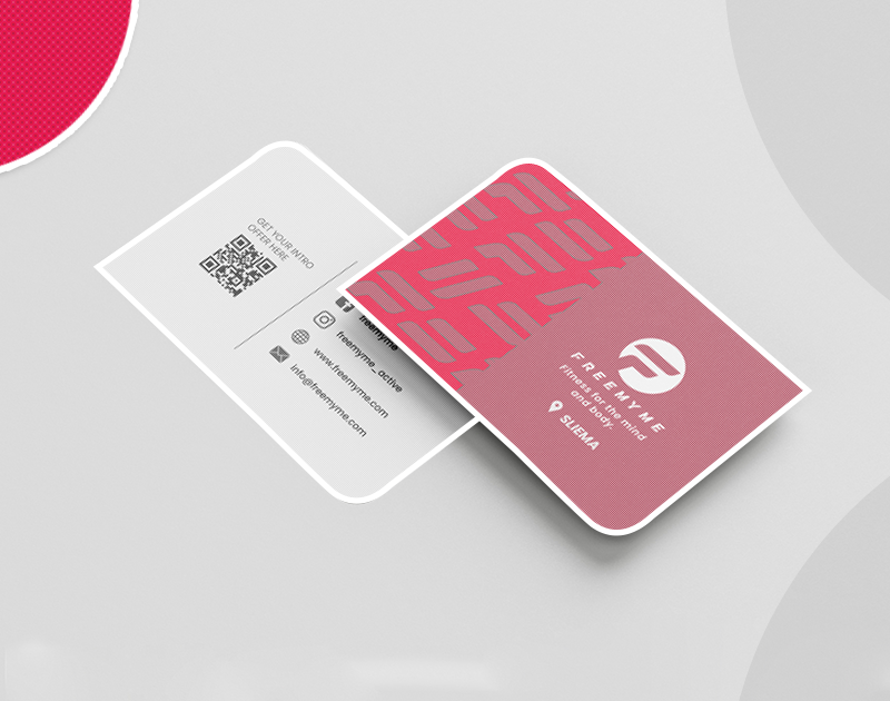 Two business cards on a light surface; one shows contact details and a QR code, the other displays a pink and white company logo for FreeMyMe.